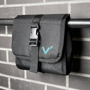 image of black Volt Go Pack hanging on bar against gray brick wall